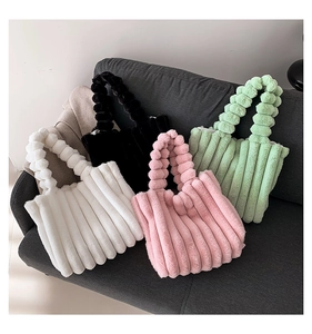 Detail of plush tote bags in white, black, pink and green with soft vertical padding