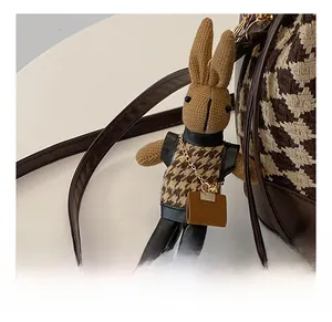Détail du charm lapin en tricot avec gilet en pied-de-poule et fermoir doré
