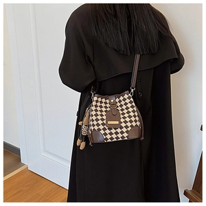 Sac seau rétro à carreaux avec garniture en cuir brun et breloque ours sur modèle