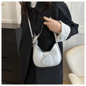 Détail du fermoir coeur argenté avec gravure LOVE sur un sac à bandoulière minimaliste