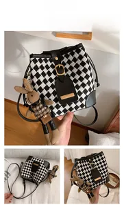 Détail du sac seau à motif pied-de-poule noir et blanc avec garniture en cuir souple