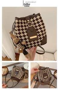 Détail d'un sac seau à motif pied-de-poule marron café avec son pendentif lapin en peluche