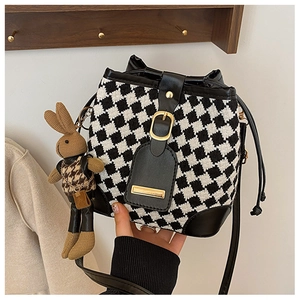 Detail of houndstooth bucket bag with leather drawstring and brown bunny charm