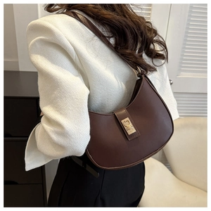 Detail of a brown crescent hobo bag with gold buckle and smooth leather texture