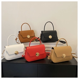 Close-up of five stylish small square bags in diverse colors with gold metal buckles