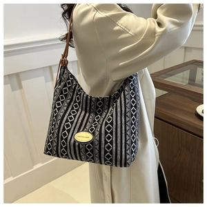Détail du sac cabas tissé avec motif géométrique et bandoulière en cuir marron