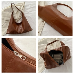 Detail view of large capacity brown hobo bag showing zipper and interior space