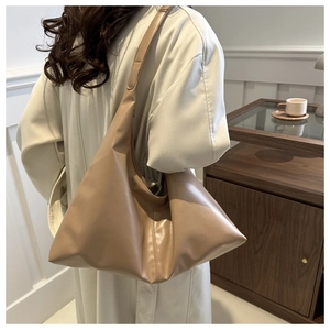 Lifestyle shot of large beige soft PU leather shoulder tote bag with wide strap