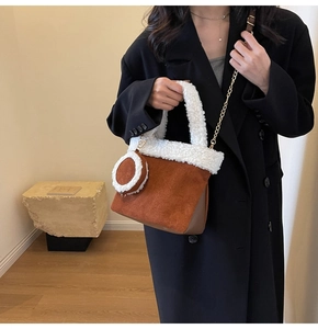 Detail der flauschigen Fleece-Verzierung an brauner Wildledertasche mit Goldkette