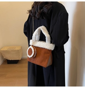 Braune Wildledertasche mit weißem Kunstfellbesatz und Goldkette an einem Model