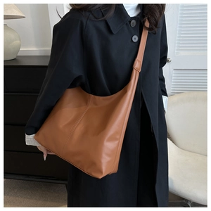 Brown large capacity PU leather hobo bag styled with a vintage coat in minimalist interior