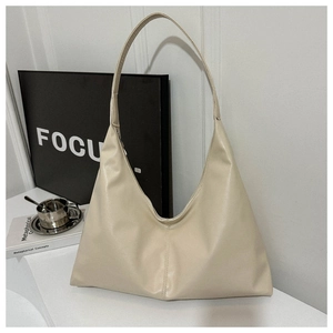 Detail view of beige hobo shoulder bag with soft leather texture and minimalist triangular shape