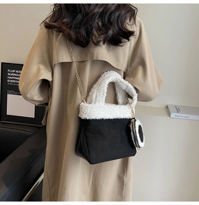 Detail der Plüschtasche in Schwarz-Weiß mit goldener Kette und kleinem Münzfach