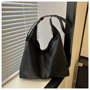 Detail of a large black PU leather hobo bag featuring adjustable strap and silver metal buckle