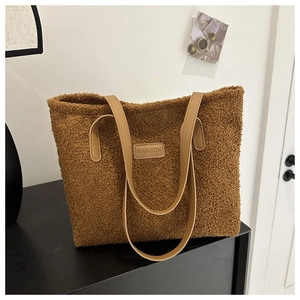 Detail of soft brown teddy plush tote bag featuring leather straps and FASHION patch