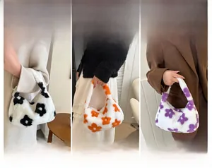 Dettagli di borse di peluche a fiori nei colori nero, arancione e viola per l'inverno