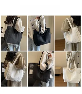 Detail shots of large canvas tote bags in black and beige with side pockets and metal hardware