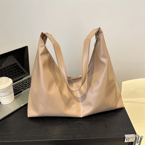 Chic beige soft leather tote bag on office desk with laptop and coffee cup