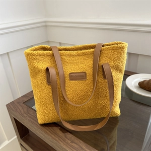 Fashionable yellow plush faux fur tote bag with brown leather straps and logo patch