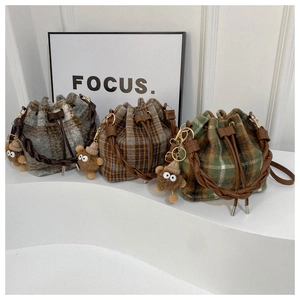 Detail of vintage plaid wool bucket bags with leather woven handles and cute plush charms