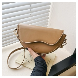 Detailed close-up of a vintage brown saddle bag with smooth leather and gold hardware