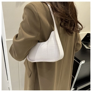 Close-up of white crocodile pattern hobo bag worn with a stylish brown blazer jacket
