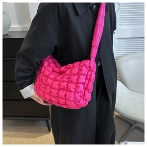 Close-up of bright pink quilted puffer shoulder bag with soft textured nylon finish