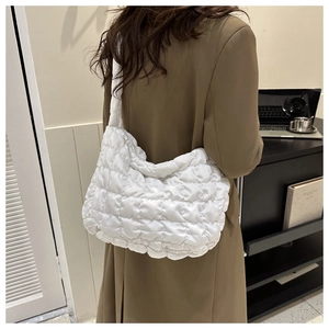 Detail view of the white quilted cloud tote bag showing soft ruffled texture on shoulder
