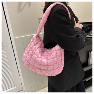Detail of pink quilted puff shoulder bag with 3D texture and gold metal zipper