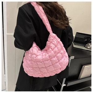 Pink quilted bubble hobo bag worn by a model in a modern office setting for a chic look