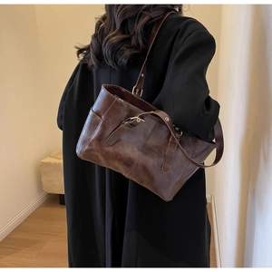 Detalle del bolso tote de cuero marrón vintage con hebilla dorada en la correa