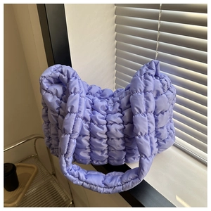 Detail of purple quilted bubble fabric and puffy texture on a large shoulder bag