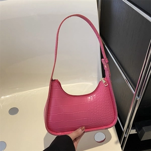 Pink faux crocodile leather underarm bag with curved design and sleek shoulder strap