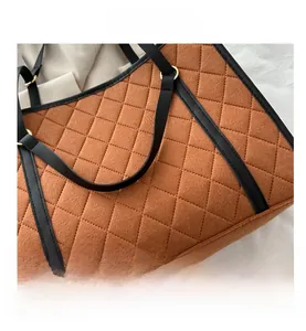 Detail of brown quilted felt tote bag with contrast black synthetic leather piping and seams