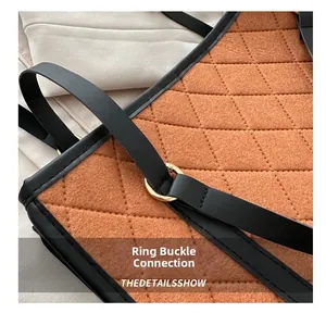 Detail of quilted orange felt bag with black leather strap and gold metal ring buckle
