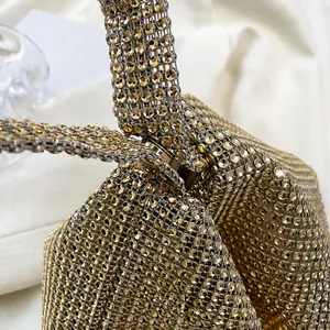 Makroaufnahme von goldfarbenem Strass-Gewebe und Metallschließe der Abendtasche