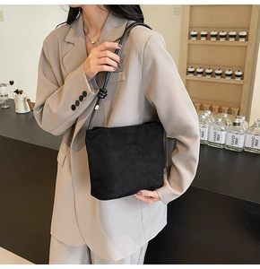 Detail of minimalist black matte tote bag featuring Fashion and Sunday embossed text