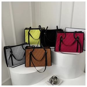 Macro shot of stylish quilted felt tote bags in five vibrant colors with leather straps