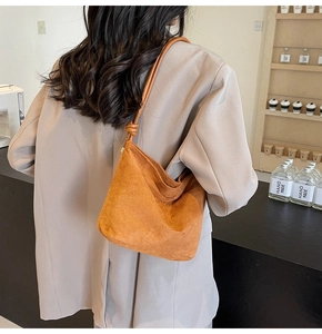 Detail of the unique knot strap design on a caramel suede tote bag for women