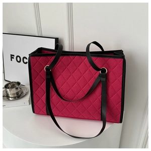 Macro view of magenta quilted tote bag showing diamond stitching and black leather piping