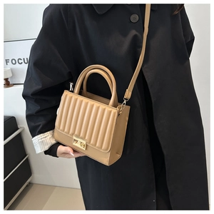 Detail of khaki PU leather crossbody bag with vertical quilted flap and gold twist lock