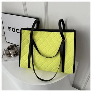 Detail of neon quilted felt tote bag with black trim and dual shoulder straps