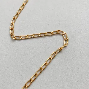 Detailansicht der polierten goldenen Metallkette am Riemen einer Designer-Handtasche