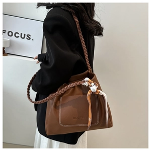 Détail du sac à bandoulière marron texture litchi avec anses tressées et foulard en soie