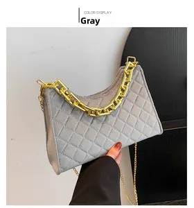 Details einer grauen gesteppten Umhängetasche mit goldener Kette und glattem Finish