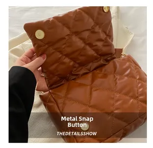 Dettaglio di una borsa trapuntata in pelle PU marrone con doppia chiusura magnetica in metallo