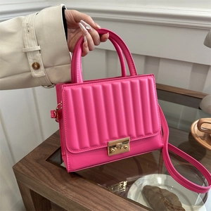 Magenta ribbed quilted handbag with golden twist lock and thin shoulder strap