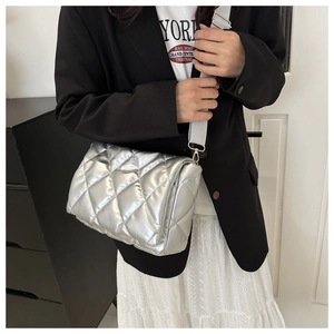 Borsa trapuntata argento con tracolla larga indossata da una modella stile moderno