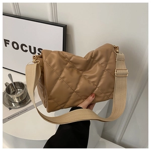 Dettaglio borsa trapuntata marrone in ecopelle con tracolla beige e finiture in metallo oro