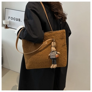 Borsa tote marrone in pile con tracolla in pelle e ciondolo a coniglio su modella